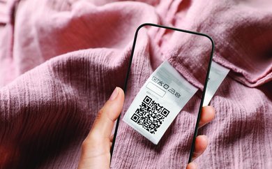 Handyscreen über Textilie mit Bild des QR-Codes auf der rosafarbenen Textilie