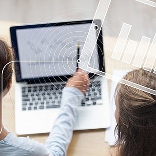Eine Frau zeigt einer anderen Frau etwas auf einem Bildschirm