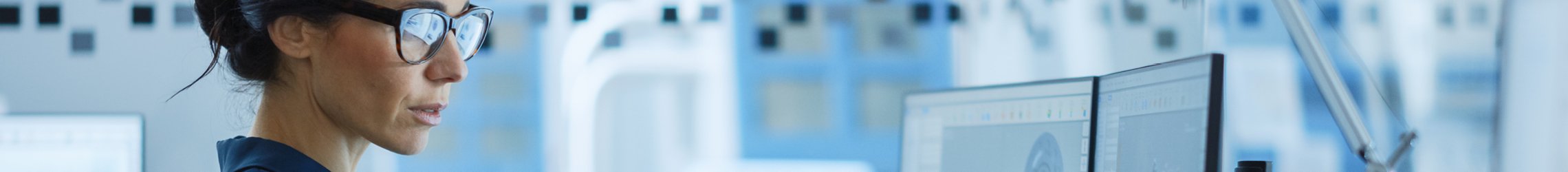 Keyvisual: Frau mit Brille sitzt an Computer