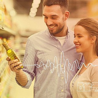 Shopper Experience: Mann und Frau stehen vor einem Supermarktregal und betrachten eine Angaben auf einer Flasche