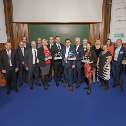Gruppenbild der Gewinner des Healthcare Awards 2018, stehend auf blauem Boden