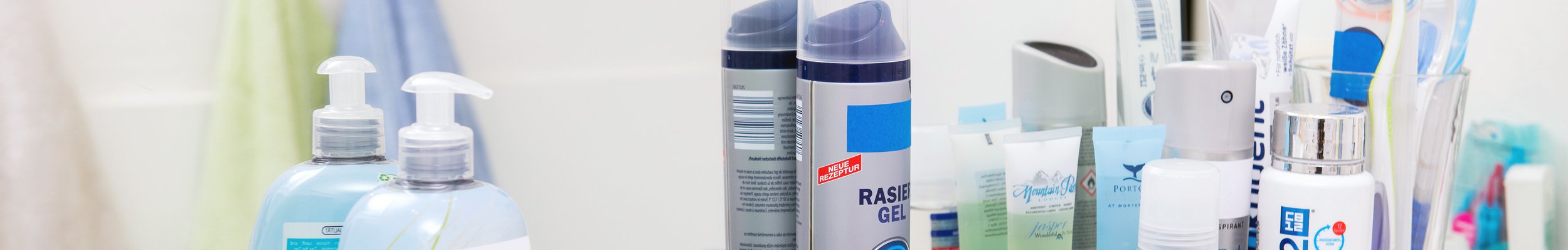Kostmetikprodukte auf Ablage vor Badezimmerspiegel