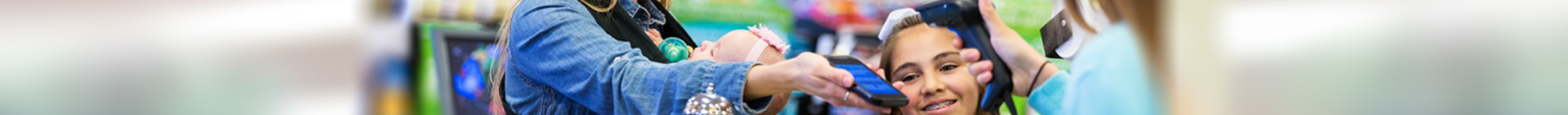 Eine Frau löst an der Supermarktkasse einen Coupon ein