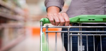 Eine Frau schiebt einen Einkaufswagen durch den Supermarkt