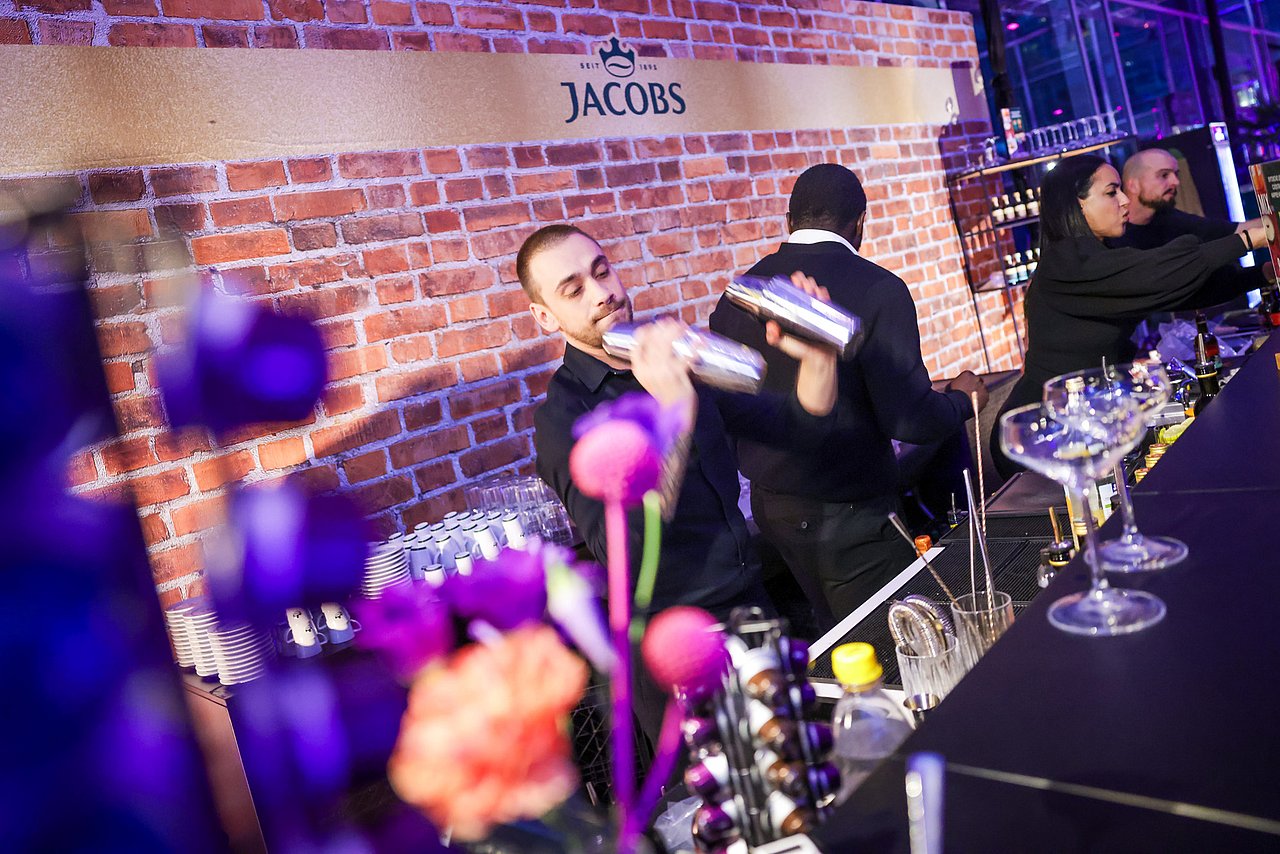 Ein Barkeeper mixt auf der ECR iN MOTiON Party einen Cocktail
