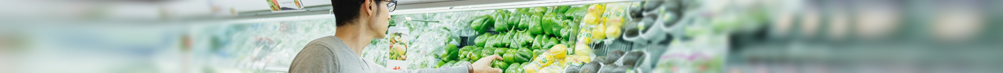 Ein Mann vor dem Gemüseregal im Supermarkt