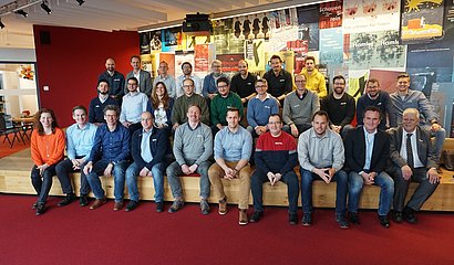 Gruppenfoto der Blockchain-Kickoff-Gruppe vor buntem Hintergrund 