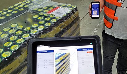 Foto eines Smartphones mit digitalem Lieferschein und einer Warenanlieferung