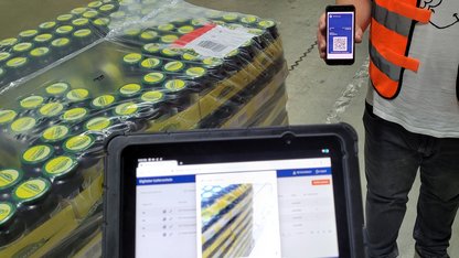 Foto eines Smartphones mit digitalem Lieferschein und einer Warenanlieferung