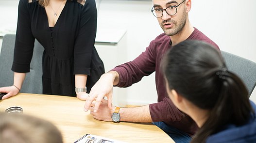 Teammitglieder sitzen an einem Tisch zusammen und brainstormen