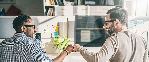 Zwei Männer geben sich im Büro einen Handschlag