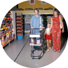 Zwei Frauen gehen in den 70er Jahren im Supermarkt mit Einkaufswagen einkaufen
