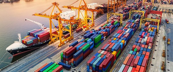 Supply Chain Management mit GS1 Standards fest im Griff Containerhafen mit Schiff und LKWs soll Supply Chain Management visualisieren