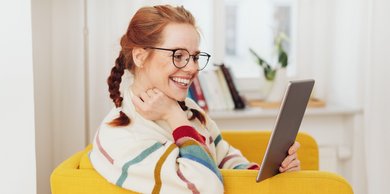 Eine junge Frau liest etwas auf einem Tablet