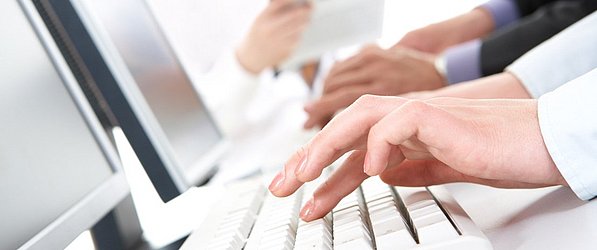 Person tippt auf einem Laptop