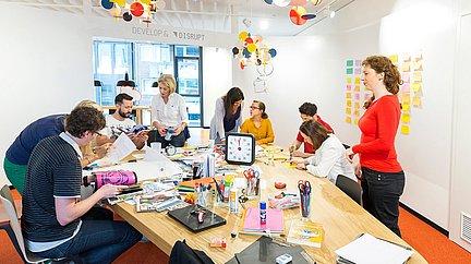 Personengruppe sitzt arbeitend an einem Tisch im Innovation Center 