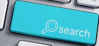Tatstatur mit einer blauen Taste mit Lupe und der Aufschrift Search