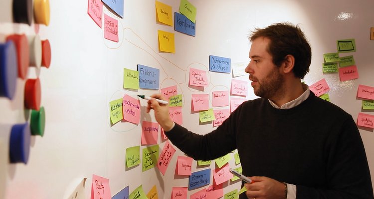 Fotografie Innovation Center - Ein Mann klebt Zettel an die Wand im Hub
