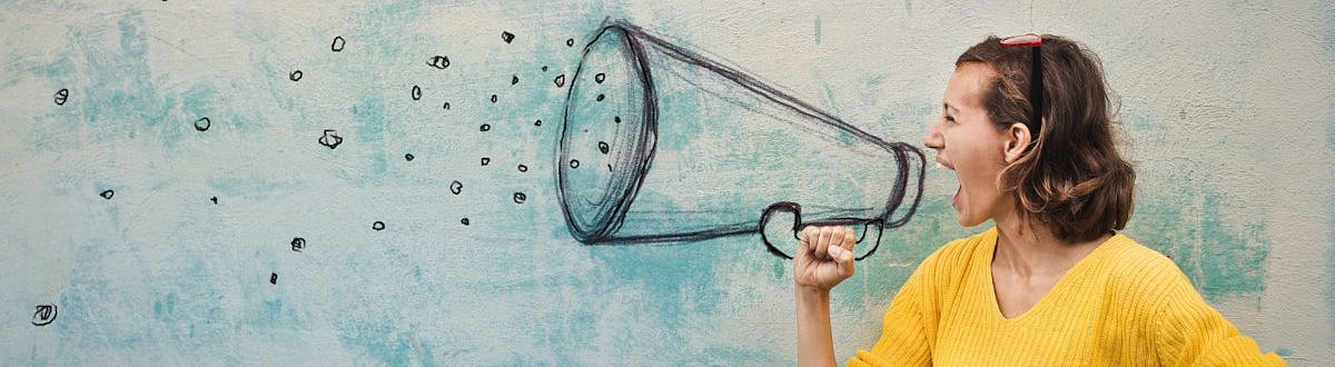 Eine Frau schreit in ein Megaphone