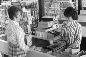 Frau beim Einkauf an einer Kasse mit UPC Scanner