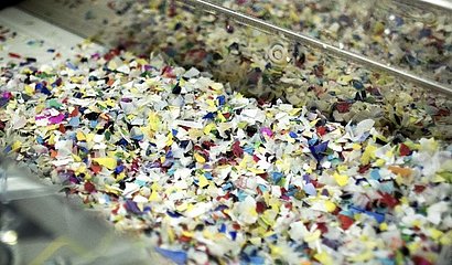 Foto zeigt farbige Kunststoff Flakes, die als Rezyklat wiederverwendet werden