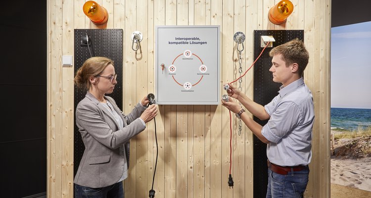 Technologies Experience - Zwei Personen versuchen verschiedene Stecker und Steckdosen zusammen zu stecken