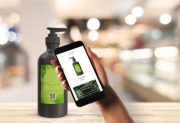 Ein Kunde scannt den Code auf einer Shampooflasche mit seinem Smartphone