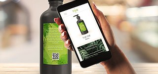 Ein Kunde scannt den Code auf einer Shampooflasche mit seinem Smartphone