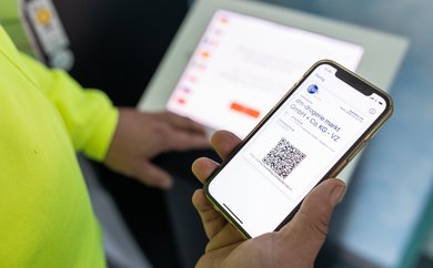 Digitaler Lieferschein wird als QR-Code auf Smartphone des LKW-Fahrers angezeigt