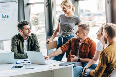 Eine Gruppe von jungen Leuten unterhalten sich im Büro