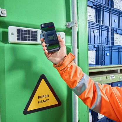Sasch Container mit Sensoren, im Vordergrund ein hochgehaltenes Smartphone mit Barcode auf dem Bildschirm