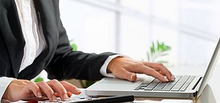 Eine Business Person vor einem Laptop