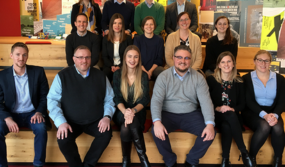Foto Teilnehmer des Lehrgangs zum zertifizierten GS1 Online Category Manager auf rotem Untergrund und buntem Hintergrund