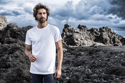 Ein Bild von einem Mann vor einer Felsenlandschaft mit einem weißen T-Shirt von promodoro