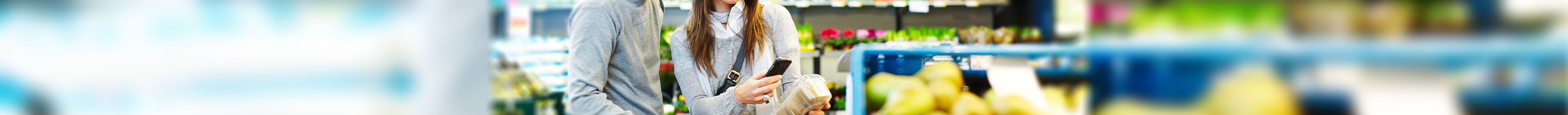 Ein Paar in einem Supermarkt scannt ein Produkt mit dem Smartphone