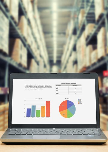 Laptop vor Regalen mit Waren in Lagerhalle: SKU (Stock Keeping Unit) hilft bei der digitalen Verwaltung und Steuerung