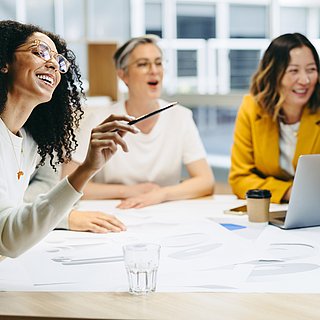 Eine Gruppe von Personen sitzt zusammen am Tisch und lernt