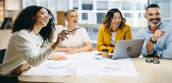 Eine Gruppe von Personen sitzt zusammen am Tisch und lernt