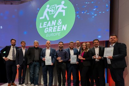 Preisträger:innen der Lean and Green Auszeichnungen zusammen mit GS1 Germany auf dem DLK 2023 auf der Bühne vor Lean and Green Logo