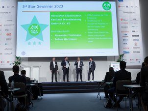 Gruppenbild 4 Personen auf Bühne