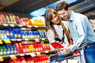 Im Supermarkt wird eine Shampoo Flasche mit einem Tablet gescannt