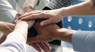 Gemeinsam Eine Gruppe von Menschen legt die Hände zusammen