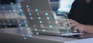 Eine Person sitzt vor einem Laptop und sucht etwas