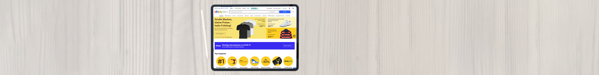 Schreibtischoberfläche mit einem Tablet und der geöffneten Startseite von ebay