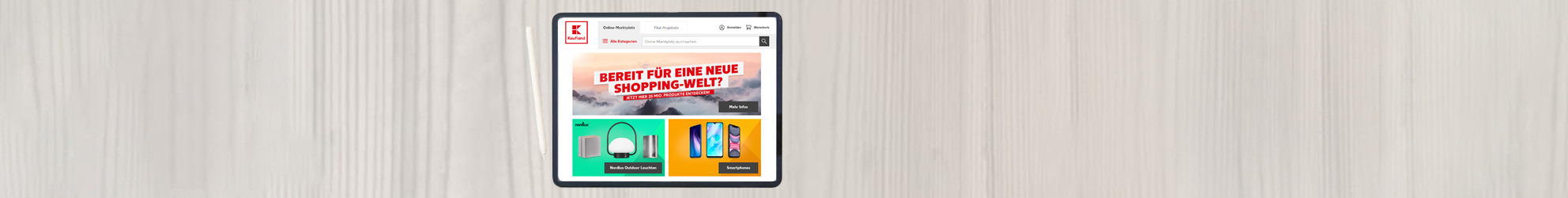 Schreibtischoberfläche mit einem Tablet und der geöffneten Startseite von Kaufland.de